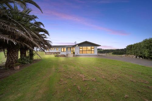 a house with a palm tree in front of a yard at Apartment 3 in Auckland