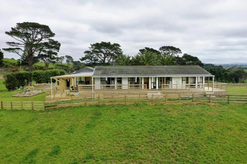 a house in a field with a fence at Apartment 3 in Auckland