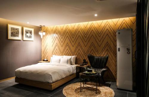 a bedroom with a bed and a desk and a chair at Mari Hotel Terminal Branch in Jeonju
