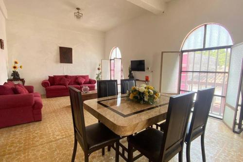 a living room with a table and a red couch at Casa Polita in Chiapa de Corzo