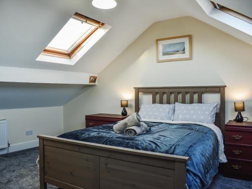 a bedroom with a bed with a blue comforter at Seymour House in Bishop Auckland