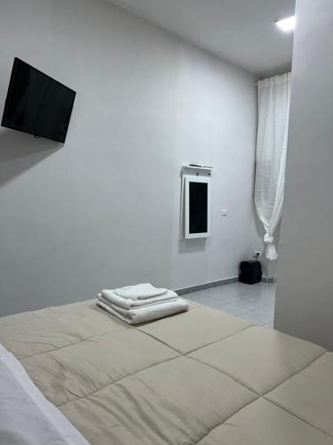 um quarto branco com uma cama e uma televisão de ecrã plano em Casina Portici em Portici