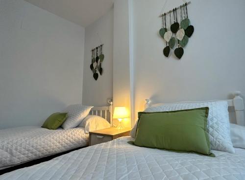 Un dormitorio con una cama con una almohada verde. en Apartamento El Pilar, en Güéjar-Sierra