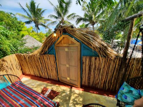 a small hut with a fence and two chairs at Casa Jade Ecobungalows Las coloradas in Yuluc