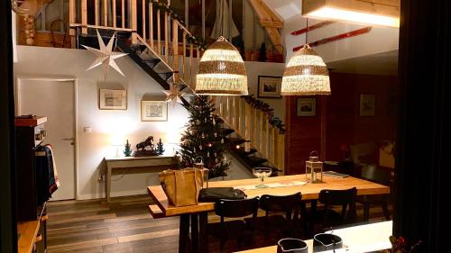 uma sala de jantar com uma mesa e uma árvore de Natal em Le Chalet de Castille - chalet pyrénéen grand confort - spa em Beaucens