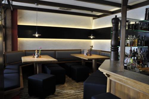 un restaurant avec deux tables et des chaises ainsi qu'un bar dans l'établissement Rennsteighotel Herrnberger Hof, à Neuhaus am Rennweg
