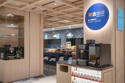 a restaurant with a coffee shop with a sign on the wall at Holiday Inn Express Beijing Downtown by IHG in Beijing