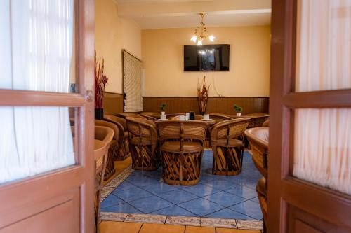 Habitación con mesa, sillas y TV. en Hotel Estefania, en Morelia