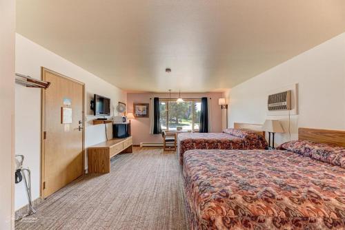 Cette chambre comprend deux lits et une télévision. dans l'établissement Moriah Motel, à Sheridan