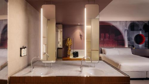 a hotel room with two sinks and a bed at Hotel Indigo Sydney Potts Point by IHG in Sydney