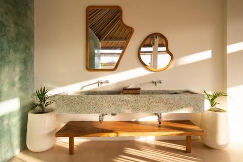 a bathroom with a large sink and a mirror at ALANA PENIDA HOTEL in Batununggul