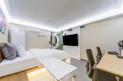 a hotel room with a bed and a couch and a table at Hotel The Araboda in Gwangju