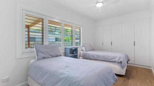 a bedroom with two beds and a window at 60 Yamba Street Hawks Nest in Sydney