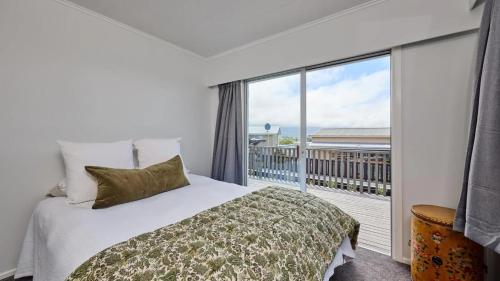 a bedroom with a bed and a large window at Views on Churchill in Kaikoura
