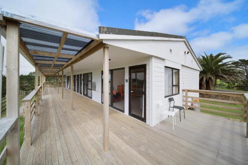 a white house with a wooden deck at Apartment 4 in Auckland