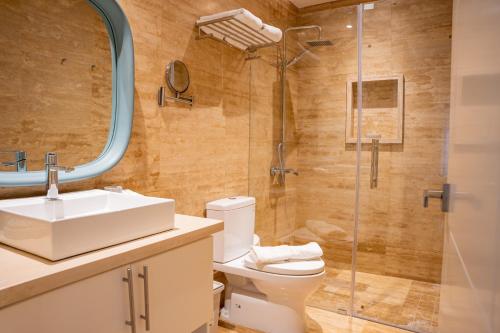 een badkamer met een toilet, een wastafel en een douche bij Fortunity Beach Tower-2 BDR with pool view in San Felipe de Puerto Plata