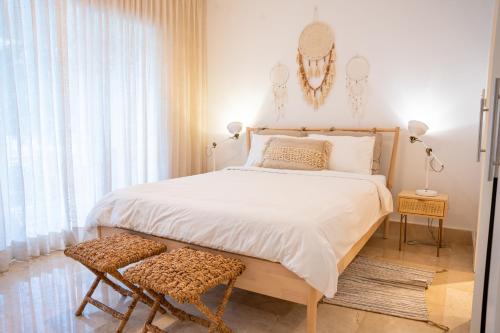 a bedroom with a large bed and a chair at Fortunity Beach Tower-2 BDR with pool view in San Felipe de Puerto Plata