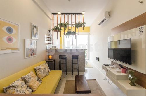 sala de estar con sofá amarillo y chimenea en Unbeatable Studio W Pool, Wifi In Villa Morra en Asunción