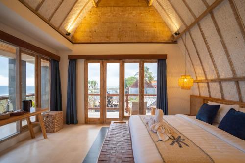 - une chambre avec un lit et une vue sur l'océan dans l'établissement ALANA PENIDA HOTEL, à Batununggul