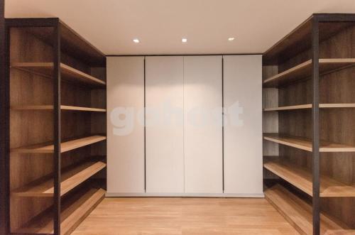 a closet with wooden shelves and white cabinets at Exclusive And Luxurious Penthouse In Herrera in Asuncion