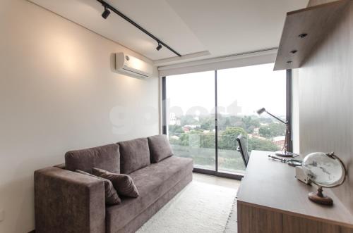 a living room with a couch and a large window at Exclusive And Luxurious Penthouse In Herrera in Asuncion