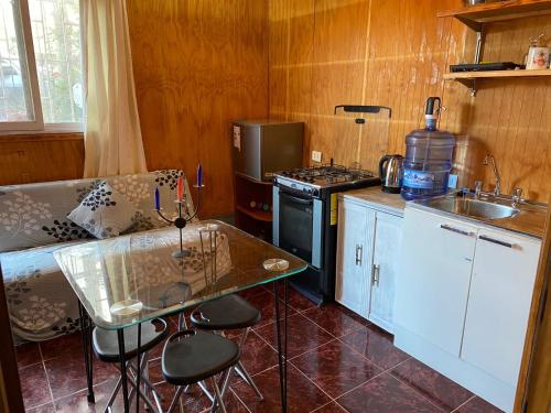 a kitchen with a table and a stove top oven at Alojamiento Interior Pichidangui in Pichidangui