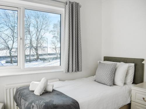 a bedroom with a bed and a large window at Glebeside Retreat in Satley