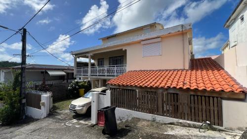 a house with a car parked in front of it at Le Ray Mundo F5 in Le Vauclin