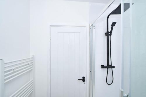 a bathroom with a white door and a shower at The Green House in Stoke on Trent