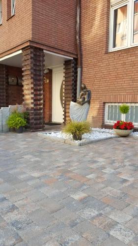 a brick building with a statue in front of it at Apartments Lindenstraße in Wilhelmshaven