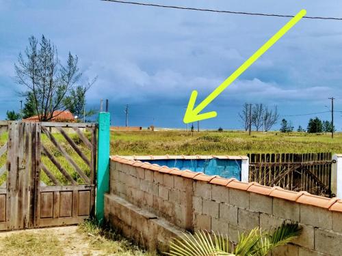 una cerca con una x amarilla en la parte superior de un campo en Apartamentos Ilha Comprida en Ilha Comprida