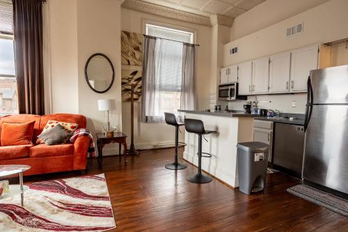 cocina y sala de estar con sofá y nevera en Cozy historic 3rdfl apartment en Baltimore
