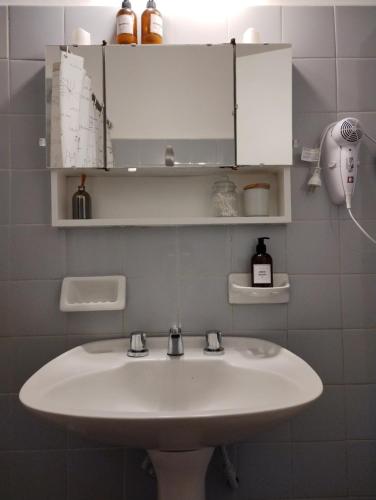 ein Badezimmer mit einem Waschbecken und einem weißen Schrank in der Unterkunft Una casita en la loma in La Plata