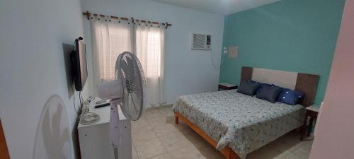 ein Schlafzimmer mit einem Bett und einem Ventilator in der Unterkunft CASA CON PILETA Y COCHERa in La Rioja