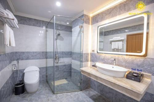 een badkamer met een wastafel en een glazen douche bij Minh Đức Hotel 