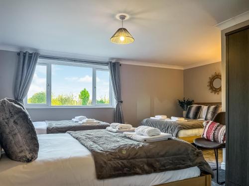 a room with three beds and a window at Bridge Farm in Uttoxeter