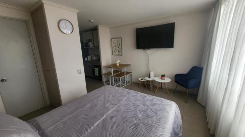 a bedroom with a bed and a flat screen tv at Edificio Matiz Central Iquique in Iquique