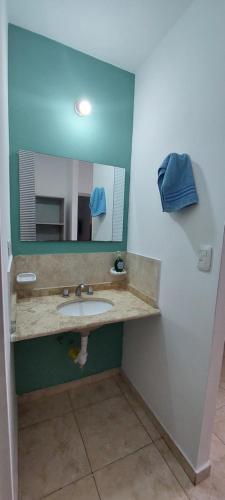 ein Bad mit einem Waschbecken und einem Spiegel in der Unterkunft CASA CON PILETA Y COCHERa in La Rioja
