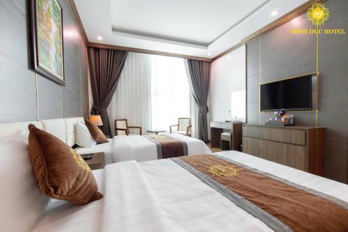 een hotelkamer met 2 bedden en een flatscreen-tv bij Minh Đức Hotel 