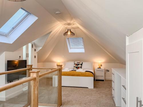 a attic bedroom with a bed and a tv at Doves Nest in Ashbourne