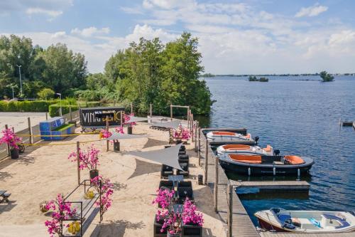 une rangée de bateaux amarrés sur la rive d'un lac dans l'établissement Leonardo Hotel Vinkeveen Amsterdam, à Vinkeveen