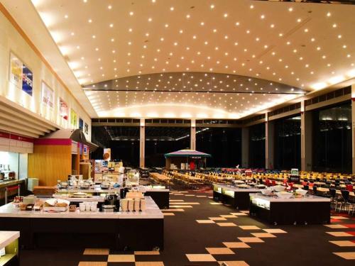 Shigakogen Prince Hotel في يامانوتشي: صالة طعام بها طاولات وكراسي وأضواء