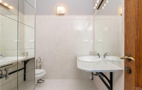 ein weißes Bad mit einem Waschbecken und einem WC in der Unterkunft Villa Baratto in Višnjan
