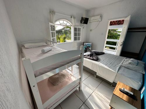 卡波布里奧的住宿－Pousada Florestinha，一间卧室设有两张双层床和一扇窗户。