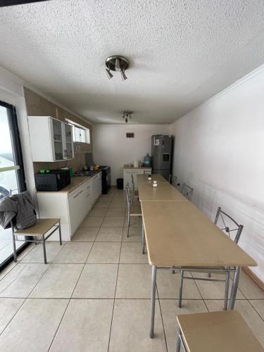 - une cuisine avec des tables et des chaises dans une pièce dans l'établissement Alojamientos OPV, à Calama