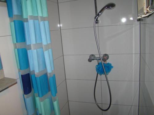 y baño con ducha y cortina azul. en Amsterhouse B&B, en Ámsterdam
