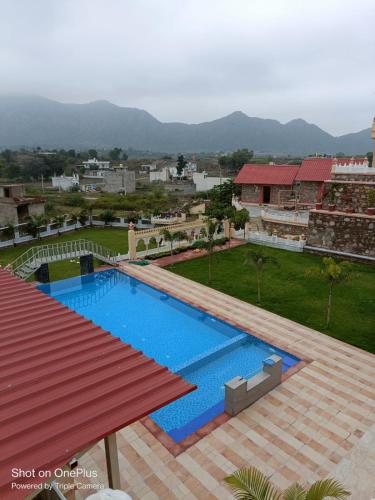 - une vue sur la piscine depuis un bâtiment dans l'établissement Jamnagar Hills resort, à Udaipur