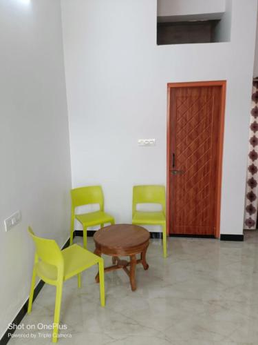 une chambre avec trois chaises, une table et une porte dans l'établissement Jamnagar Hills resort, à Udaipur