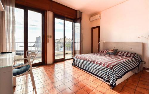 a bedroom with a bed and a balcony with windows at Stunning Apartment In Aci Castello With Kitchen in Aci Castello