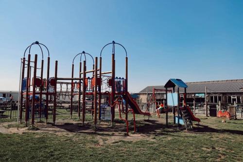 an empty playground in a park with a slide at Melrose in Leysdown-on-Sea